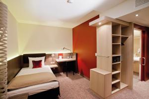 a bedroom with a bed and a desk in a room at bigBOX ALLGAEU Hotel in Kempten