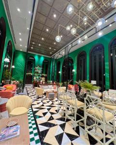 a lobby with chairs and tables and green walls at La Habana Huahin by Ying in Hua Hin