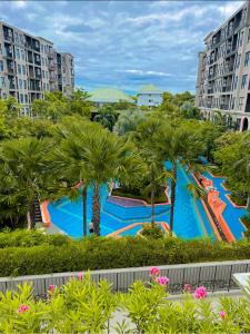 a large swimming pool with palm trees and buildings at La Habana Huahin by Ying in Hua Hin
