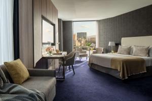 a hotel room with a bed and a table and chairs at Anantara The Marker Dublin- A Leading Hotel of the World in Dublin