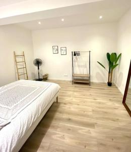 una camera con letto bianco e pavimento in legno di Le Tarasconnais a Tarascona