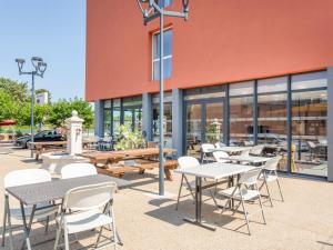 a group of tables and chairs in front of a building at B&B HOTEL Aix en Provence Venelles in Venelles