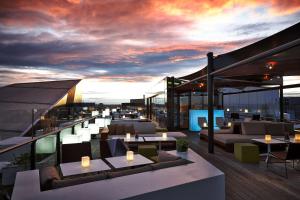a rooftop patio with couches and tables on a building at Anantara The Marker Dublin- A Leading Hotel of the World in Dublin