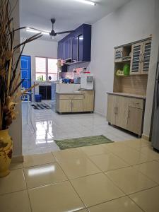 cocina con armarios azules y suelo de baldosa en Homestay MdmMai Private Pool, en Masjid Tanah