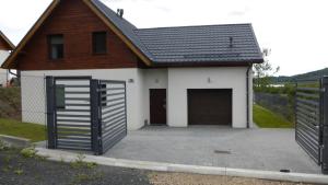 una casa con dos puertas de garaje delante de ella en Dom Nad Zalewem Sosnówka, en Sosnówka