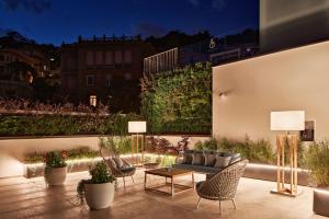 a patio with a couch and chairs and a table at The Britannique Hotel Naples, Curio Collection By Hilton in Naples