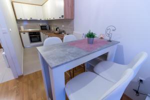 a kitchen with a blue table and white chairs at Gajeva Rooms - Malmö apartment SELF CHECK-IN in Virovitica