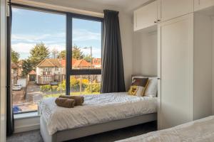 sypialnia z łóżkiem i dużym oknem w obiekcie Modern Penthouse in Wembley w Londynie