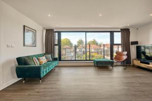 a living room with a green couch and a television at Modern Penthouse in Wembley in London