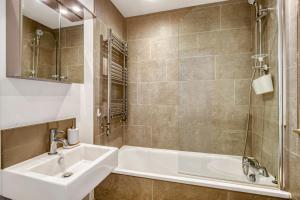 łazienka z umywalką i wanną w obiekcie Modern Penthouse in Wembley w Londynie +27 zdjęć