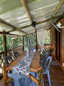 a porch with a wooden table and chairs at Hillcreek's Riverside Hideaway in Murcia