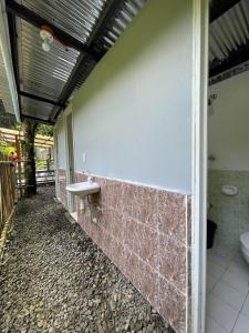 a bathroom with a toilet and a sink on a wall at Hillcreek's Riverside Hideaway in Murcia