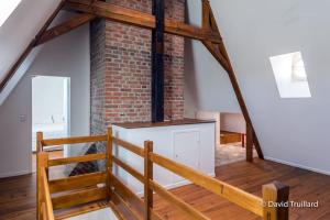 a loft with a staircase and a brick wall at Suite Mana - Maui - Place Ducale in Charleville-Mézières