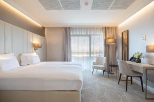 Hotel Gerardus في سيجد: غرفة الفندق بسرير كبير ومكتب