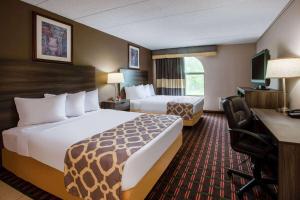 um quarto de hotel com duas camas e uma secretária em Baymont by Wyndham Northwood em Northwood