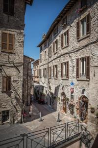 アッシジにあるApartment Assisi Cattedraleの門付きの古石造りの建物内の路地