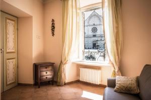ein Wohnzimmer mit einem Sofa und einem Fenster in der Unterkunft Apartment Assisi Cattedrale in Assisi