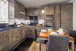 a kitchen with a wooden table and chairs in it at Crown Street 4 in Bury Saint Edmunds