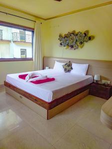 um quarto com uma cama grande e lençóis brancos em Shradha luxury room em Calangute