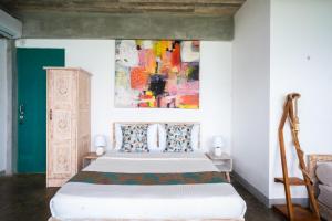 a bedroom with a bed and a painting on the wall at The Southern Gate in Ahangama