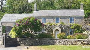 an old stone house with a stone wall at The Hideaway in Shepton Mallet