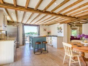 uma cozinha com tectos em madeira e uma mesa e cadeiras em The Oast House - Hartley Wine Estate em Alton