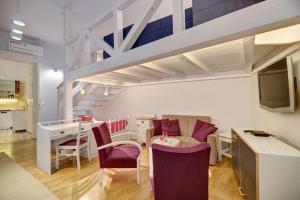 a living room with a table and chairs and a kitchen at City and Calmness in Budapest
