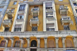 - un grand bâtiment jaune avec des fenêtres et des balcons dans l'établissement City and Calmness, à Budapest