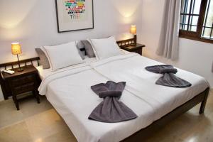 una camera da letto con un letto grande con asciugamani sopra di Panoramic Seaview Escape a Puerto de Santiago