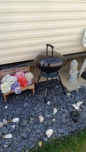 a bbq grill sitting on top of a gravel patio at Sunny Seaside chills in Saint Osyth