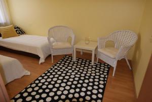 ソポトにあるSopot Apartmentの椅子2脚、ベッド1台、テーブルが備わる客室です。