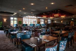 a dining room with wooden tables and chairs at Woodland Grange in Leamington Spa
