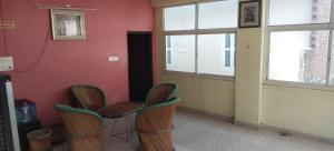a room with chairs and a red wall with windows at Mostel hotel in Jaipur