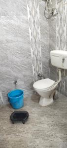 a bathroom with a toilet and a blue bucket at Mostel hotel in Jaipur