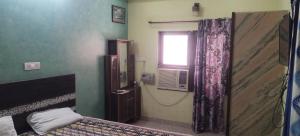 a small bedroom with a bed and a window at Mostel hotel in Jaipur
