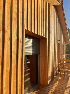 un edificio de madera con un banco en la cubierta en Refuge au coeur des Vosges en Aumontzey