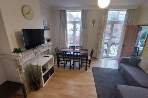 a living room with a couch and a tv and a table at Charming 1-Bedroom Apartment in Brussels