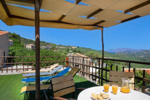 balcone con tavolo, cibo e succo d'arancia. di 4-bedroom Topolia House a Topólia