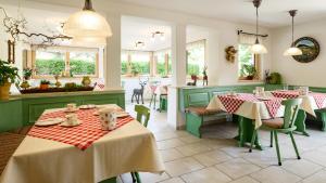 ein Restaurant mit Tischen und Stühlen in einem Zimmer in der Unterkunft Gästehaus Maier zum Bitscher in Rottach-Egern