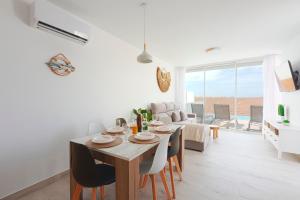 a dining room and living room with a table and chairs at VILLA PITAYA in Tías