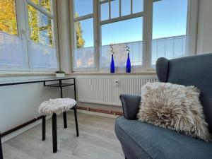 sala de estar con sofá azul y ventanas en Weimar 3-Raum Appartement, en Weimar