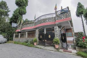 Ghum的住宿－GRG Tharbaling Homestay Darjeeling，前面有门和盆栽植物的建筑