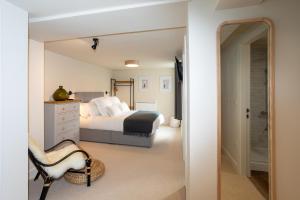 a bedroom with a king sized bed and a mirror at 30 Chipping Norton - Luxury Holiday Apartments in Chipping Norton