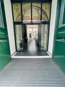 einen Eingang zu einem Gebäude mit grünen Türen und einem Flur in der Unterkunft Parkhotel Gent Centrum in Gent