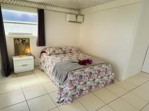 - une chambre avec un lit fleuri dans l'établissement Sable blanc, à Punaauia