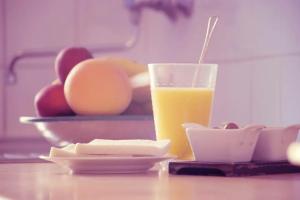un verre de jus d'orange assis sur une table avec de la nourriture dans l'établissement Sable blanc, à Punaauia