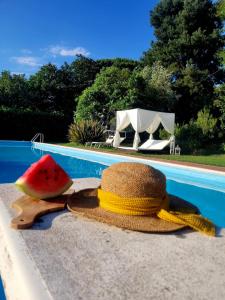 a hat and a slice of watermelon next to a swimming pool at La Tenuta Del Conte in Vignanello