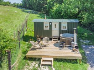 a green tiny house with a hot tub on a deck at Hot Tub Retreat - Hartley Wine Estate 