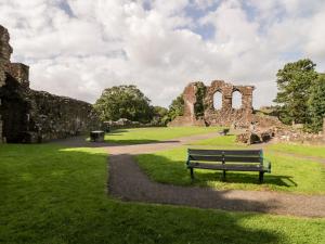 a park with a bench in front of a ruin at Vale View in Egremont