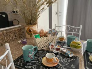 un tavolo con due tazze e un vassoio di cibo di HOLIDAY PATRIZIA'S HOME a San Giorgio Ionico